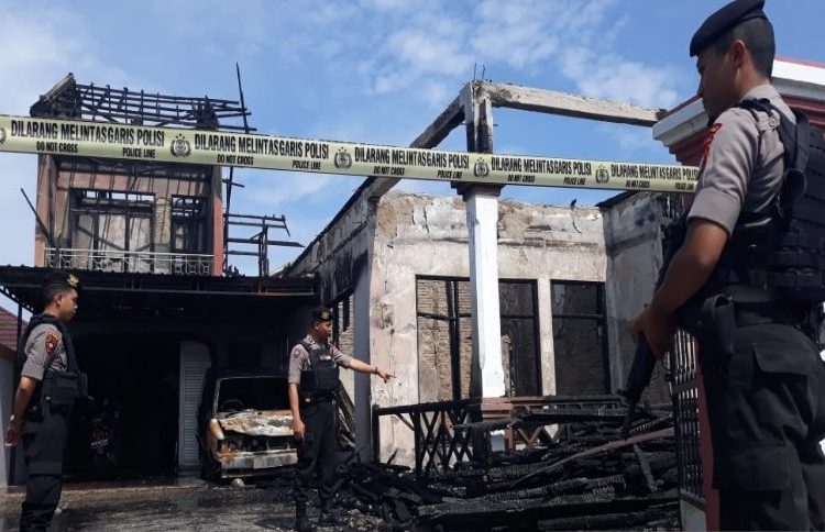Anggota Polresta Palangka Raya, Kalimantan Tengah memberi garis polisi di lokasi bangunan rumah yang terbakar di Jalan Rajawali III, Kamis (12/12/2019)