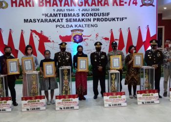 Dedet Anggota DPD KNPI Mura (Pojok Kiri Foto) Saat Menerima Piagam Penghargaan dan Tropi di Acara HUT Bhayangkara Polda Kalimantan Tengah