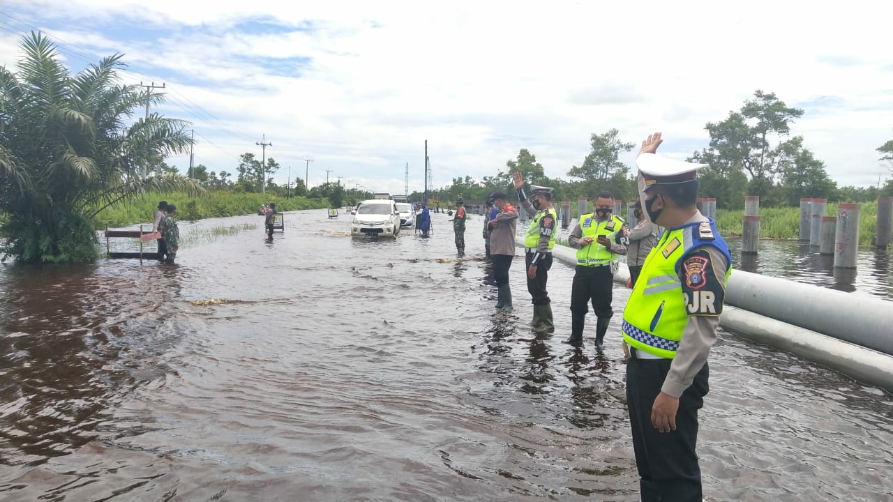 Personel Ditlantas saat berada di lokasi banjir untuk membantu pengendara