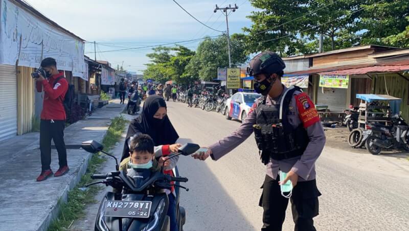 Satgas Yustisi saat memberikan masker kepada masyarakat yang ada di kawasan Pasar Besar