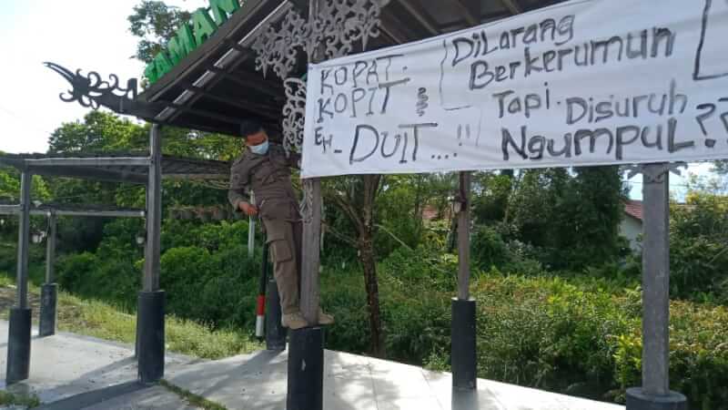 Personel Satpol PP Kota Palangka Raya melepas spanduk provokatif yang terpasang di Jalan Yos Sudarso