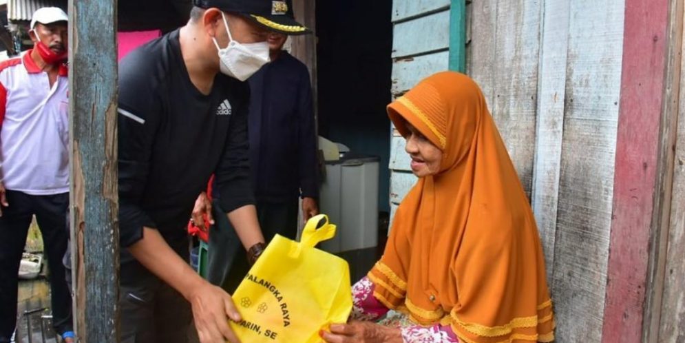 Wali Kota Palangka Raya Fairid Naparin saat memberikan bantuan bahan pangan kepada warga