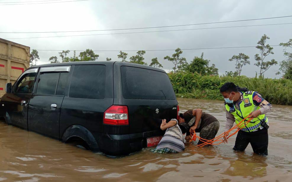 Personel Satlantas Polres Pulpis saat berupaya mengevakuasi mobil yang mogok