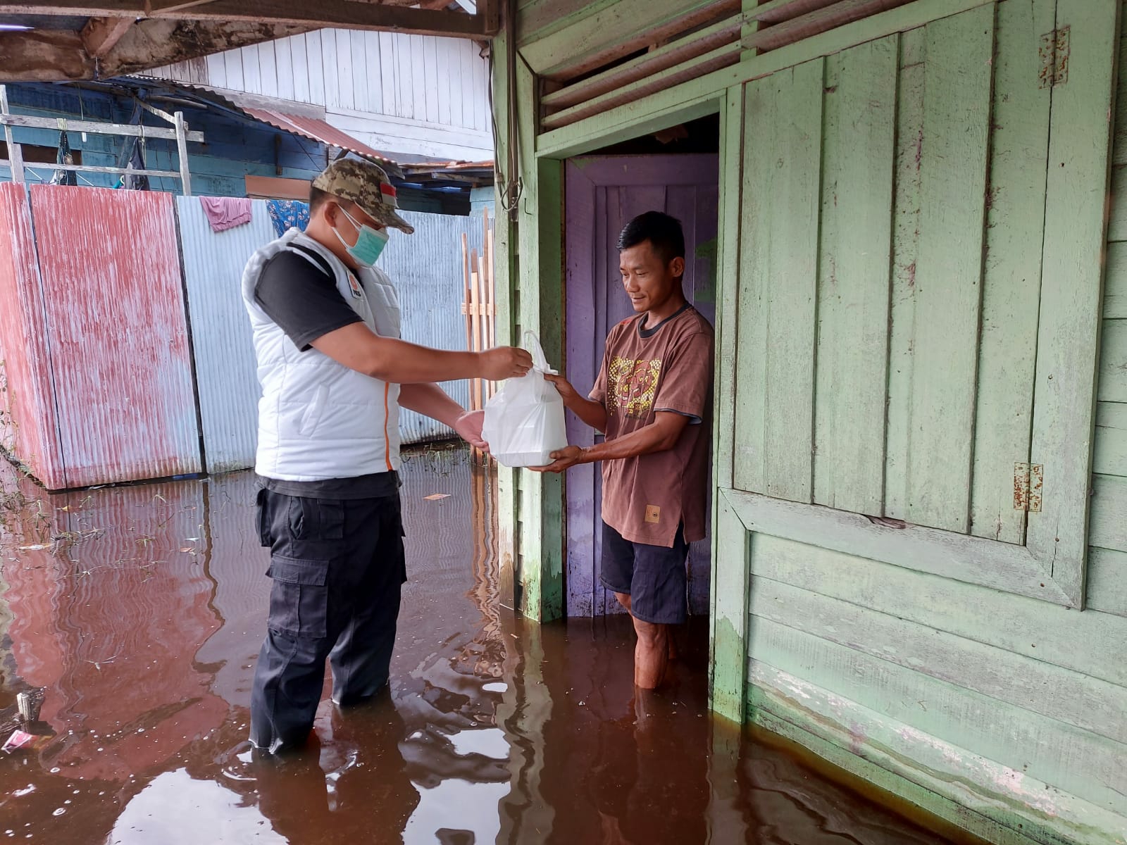 Relawan Partai Keadilan Sejahtera (PKS) Kota Palangka Raya saat memberikan bantuan kepada warga yang rumahnya terendam air akibat banjir