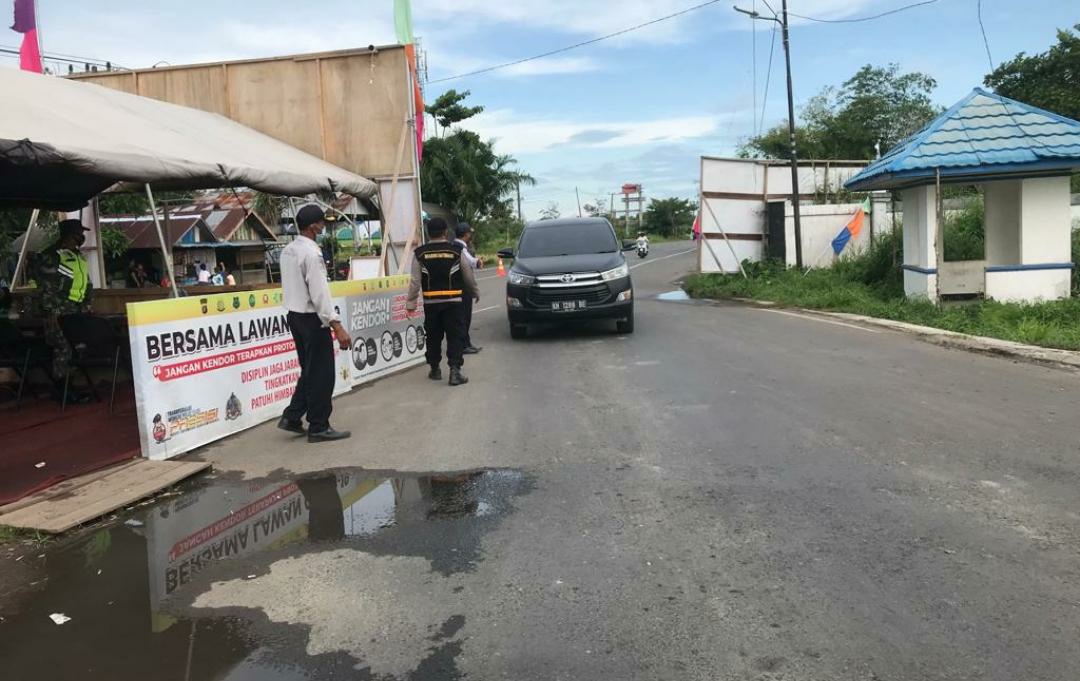 Personil polisi saat melakukan pemeriksaan kepada pengendara yang masuk ke dalam Kabupaten Kapuas sebelum posko dihentikan