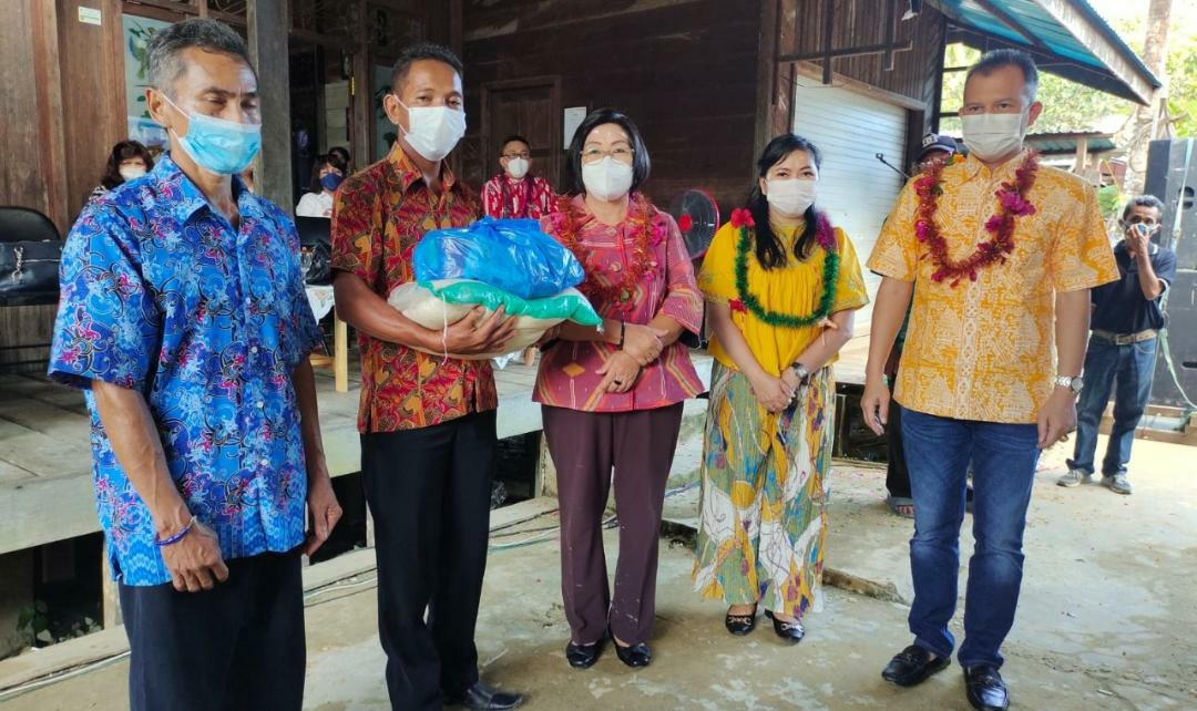 Bupati Gumas Jaya Samaya Monong didampingi Ketua TP-PKK Mimie Mariatie Jaya Samaya Monong saat menyerahkan Bantuan Sosial (Bansos) berupa paket bahan pokok secara simbolis kepada warga yang terdampak banjir di Desa Tumbang Langgah Kecamatan Rungan Barat, Sabtu (25/9/2021)