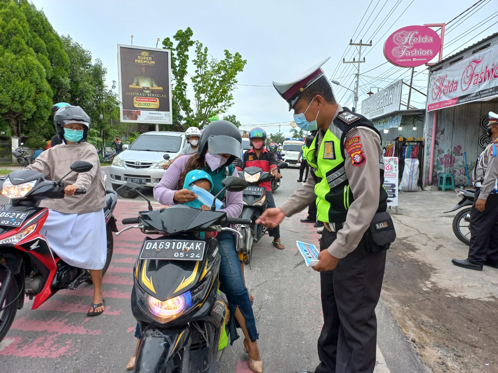 Personel Satlantas membagikan masker dalam Operasi Patuh Telabang 2021