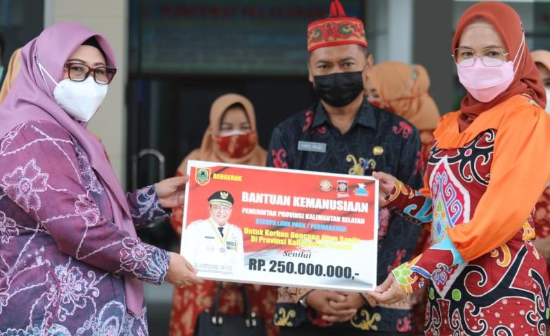 Ketua TP-PKK Provinsi Kalsel sekaligus Pembina DWP Provinsi Kalsel Hj. Raudatul Jannah saat menyerahkan secara simbolis bantuan kemanusiaan Pemprov Kalsel untuk korban bencana alam banjir di Provinsi Kalteng kepada Hj. Nunu Andriani Edy Pratowo mewakili Ketua TP-PKK Provinsi Kalteng