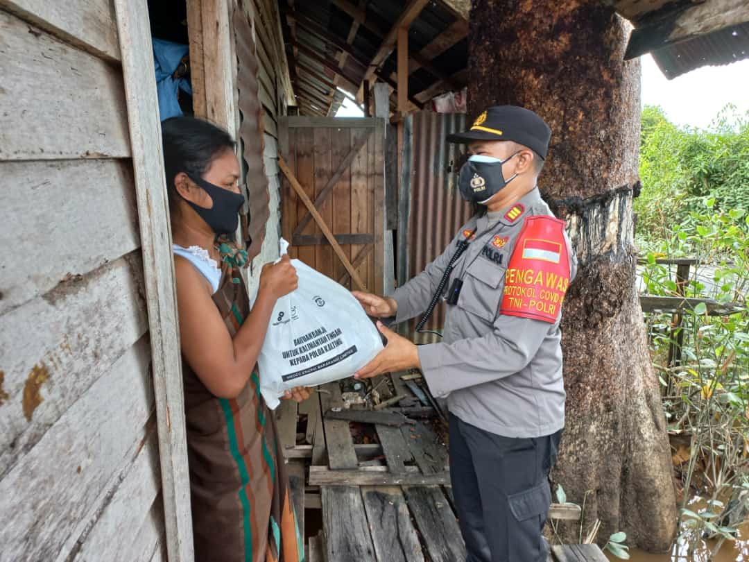 Personel Polda Kalteng ketika menyalurkan langsung bantuan kepada masyarakat di Kawasan Flamboyan Bawah 