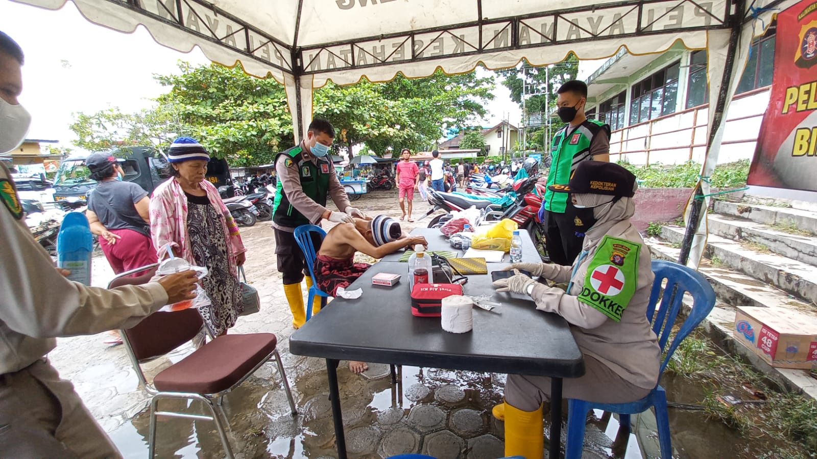 Warga korban banjir ketika menerima pelayanan kesehatan di posko Bid Dokkes Polda Kalteng