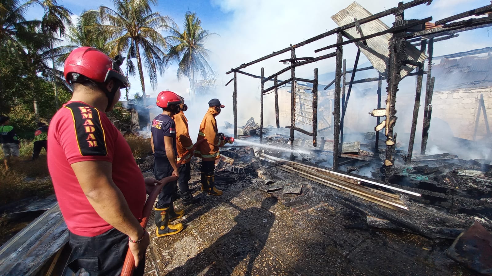 Pemadam kebakaran ketika memadamkan api yang berkobar di Jalan Keruing II