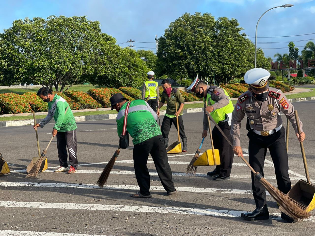 Kasat Lantas bersama petugas kebersihan saat membersihkan bahu jalan bundaran besar dari batu kerikil 