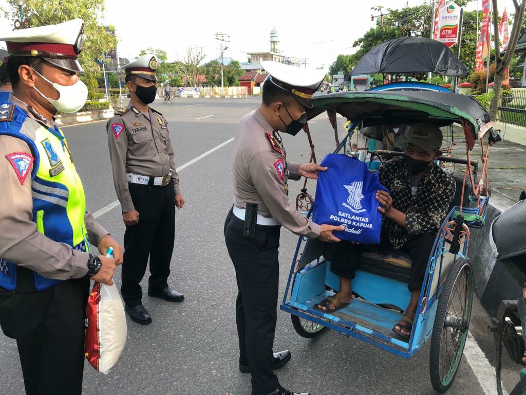 Kasat Lantas didampingi anggotanya saat memberikan bingkisan kepada tukang becak