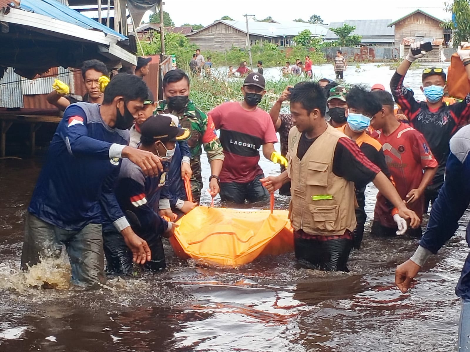 Tim gabungan ketika mengevakuasi jasad korban di lokasi banjir 