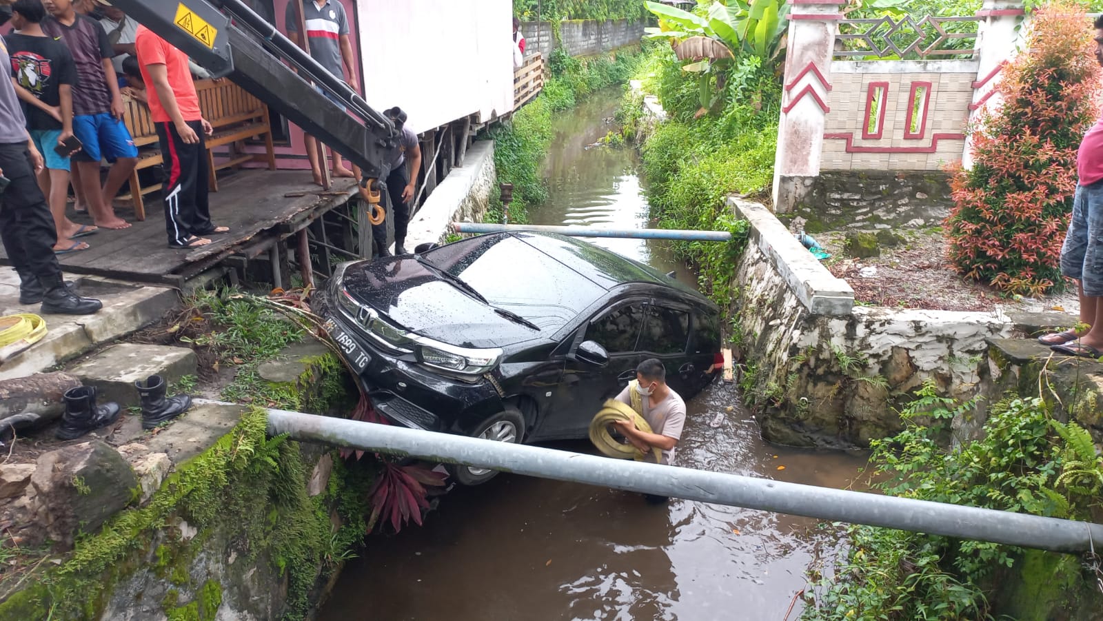 Personel Ditsamapta Polda Kalteng melakukan evakuasi terhadap mobil dari dalam parit