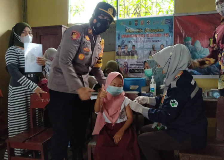 Kapolsek Kapuas Murung saat memberikan semangat kepada anak-anak yang ikuti vaksinasi