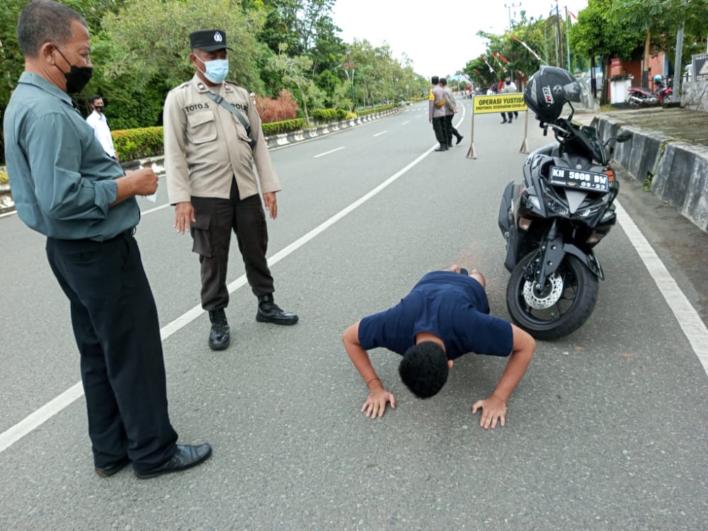 Seorang pengendara kena sanksi push up karena tidak menggunakan masker