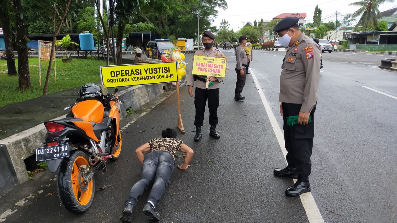 Seorang warga saat mendapatkan sanksi karena tidak menggunakan masker