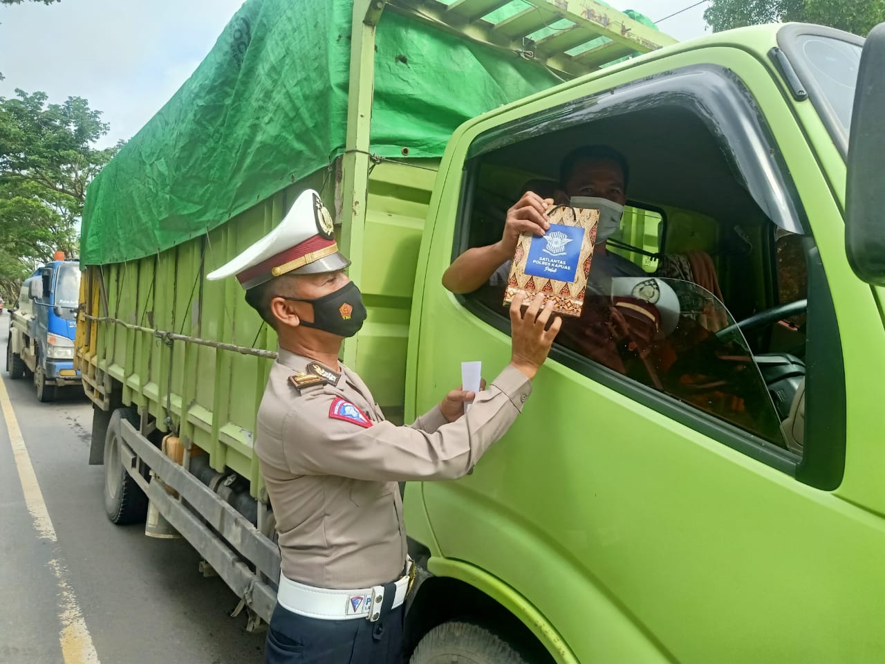 KBO Satlantas Polres Kapuas saat memberikan bingkisan usai menyampaikan imbauan kepada sopir truk