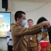 Sekda Murung Raya, Dr. Hermon, M.Si saat memasang tanda peserta kegiatan pelatihan mutu dan keamanan pangan Dinas Ketahanan Pangan, Selasa (24/5/2022)